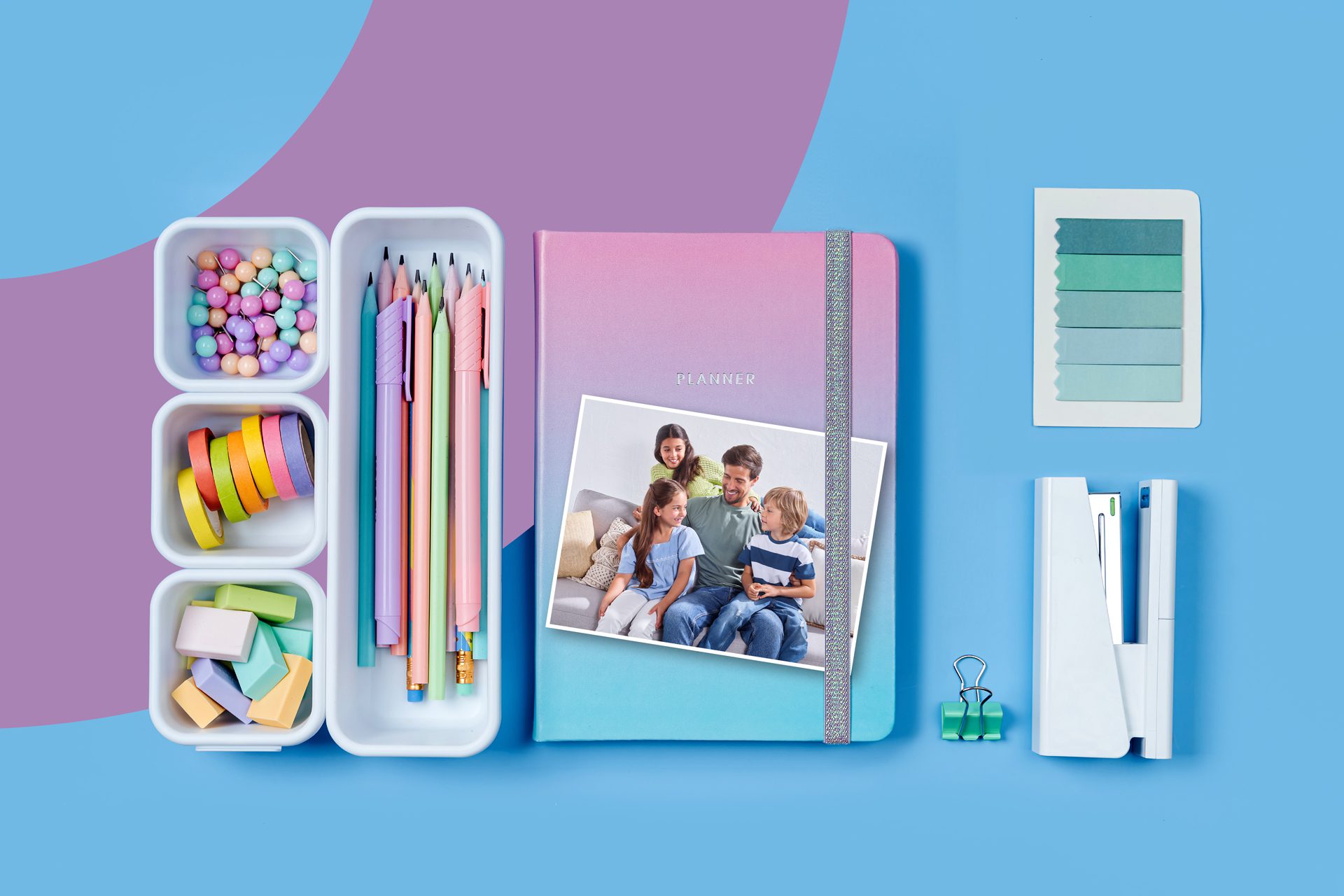Photographic composition with notebooks, pens, and school accessories in pastel tones, representing trend and lightness.